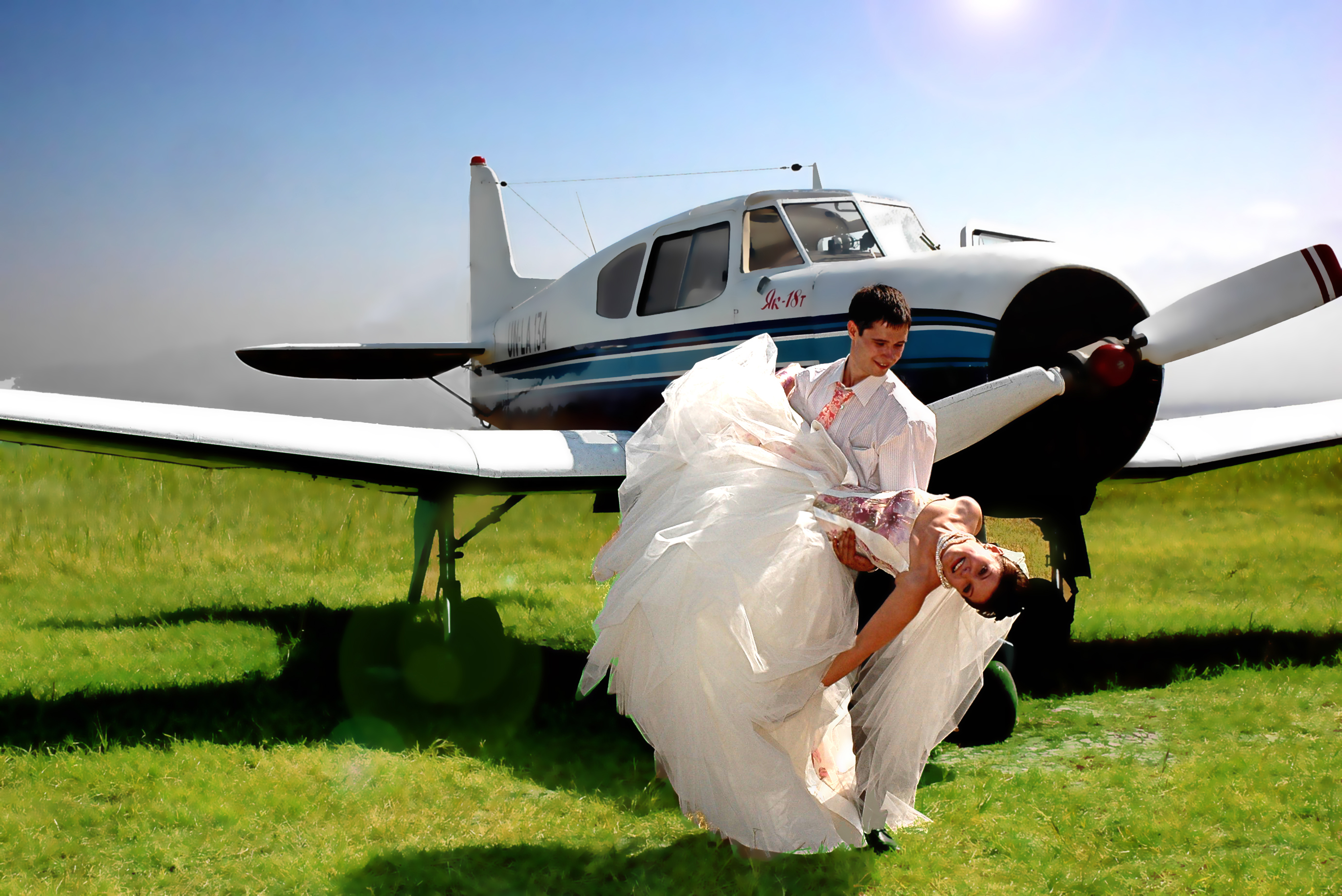 Потрачено свадьба. Свадьбы которые сыграли на открытом небе. Белые надувные вместо самолетов. Человек целует самолет.
